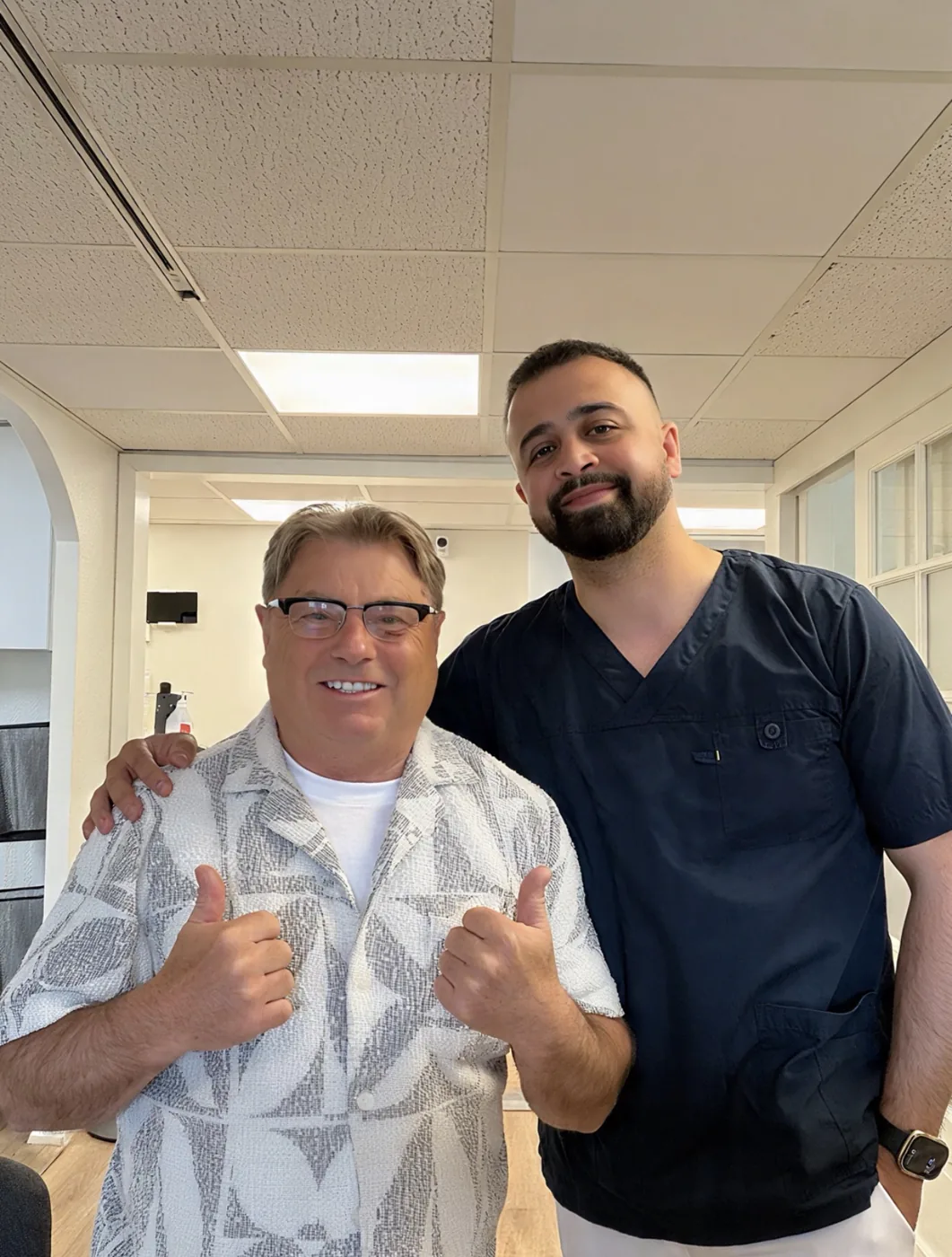 Tandläkare Omid Khatgar tillsammans med en nöjd patient på kliniken i Kinna